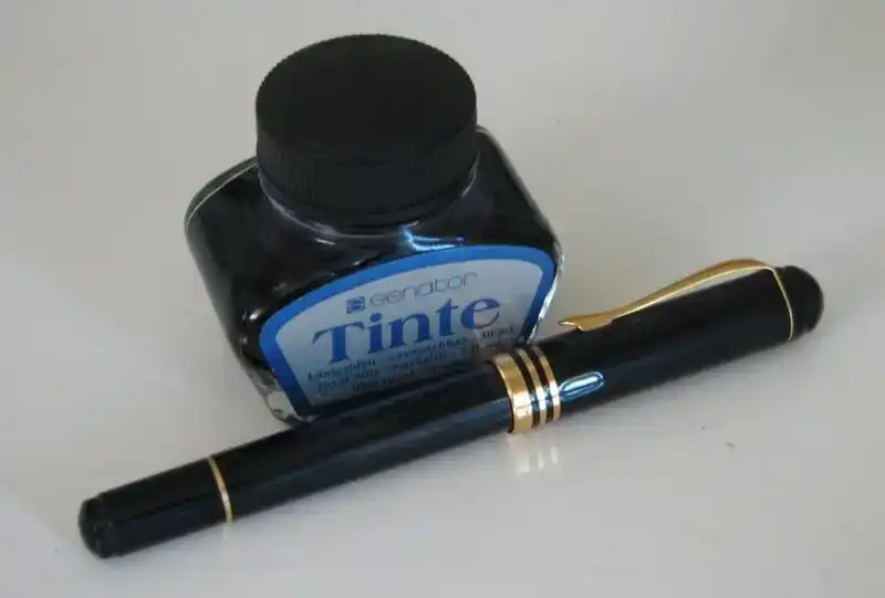 Inktpot met moderne pen, symbool voor materialen en onderhoud.